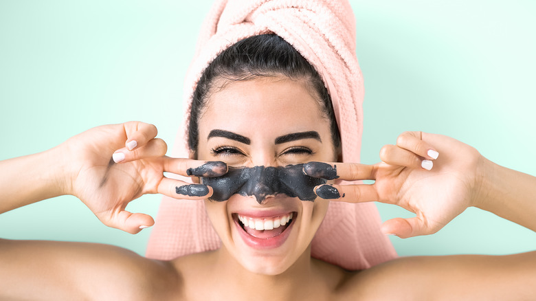 A woman wearing a clay mask