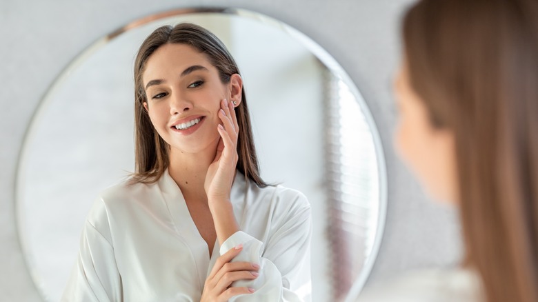 Woman looking in mirror smiling