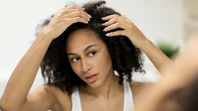 woman examining scalp