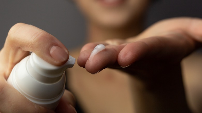 Woman dispensing face cream