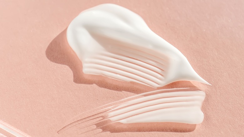 White face cream on pink background