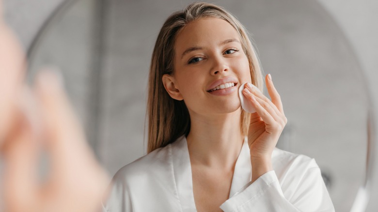 Woman doing skincare in mirror