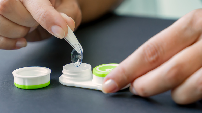 person handling contact lenses