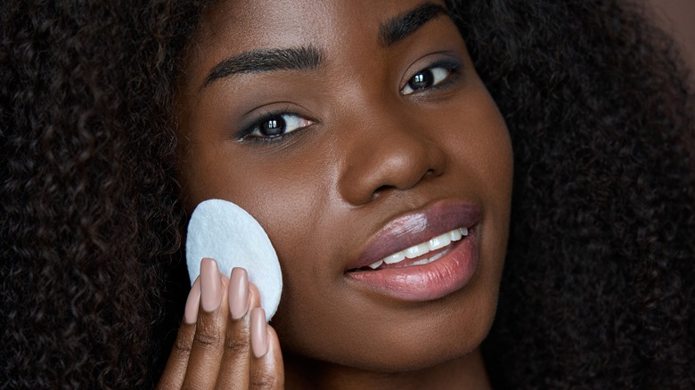 Woman applying product to her face