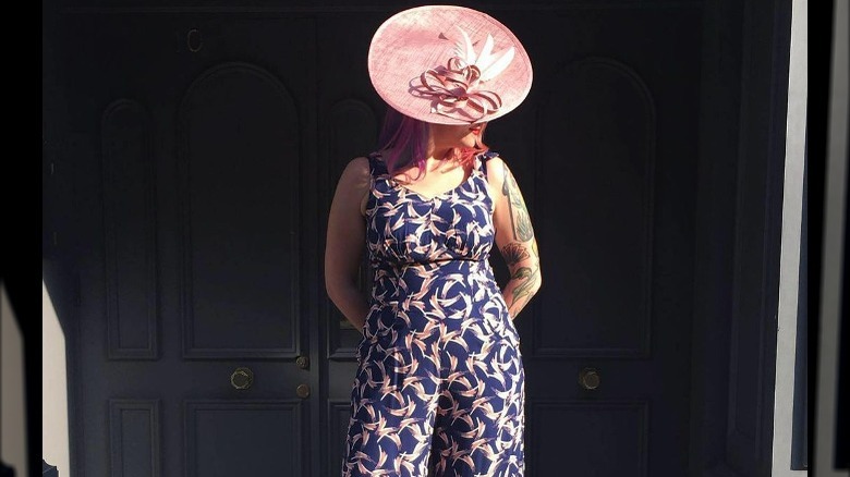 Woman in floral jumpsuit and pink hat