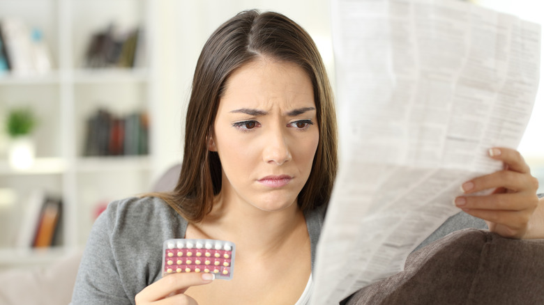 Woman reading birth control instructions