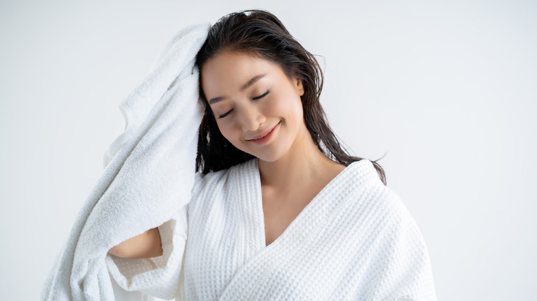 woman in robe drying hair