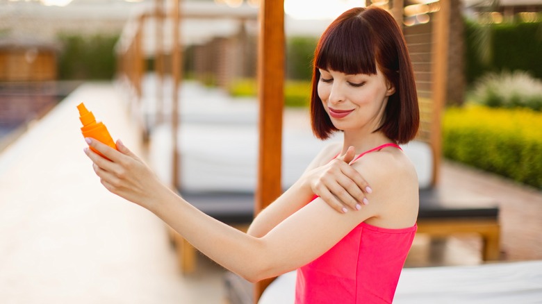 Model applying sunscreen outdoors