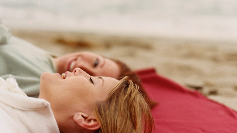 Women lying in sand, talking