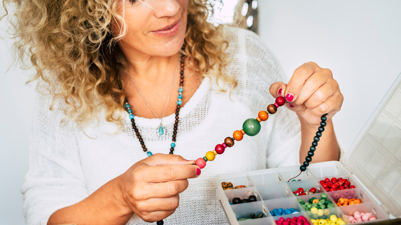 Woman making beaded necklace