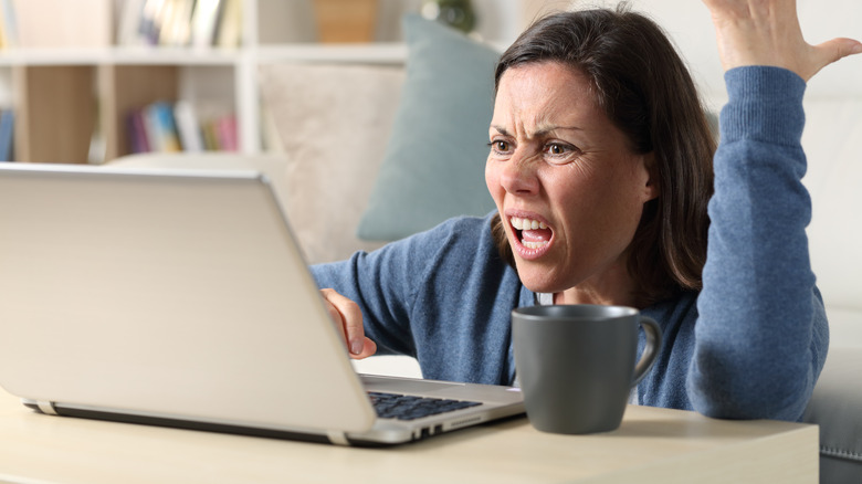 Woman becoming impatient with her laptop