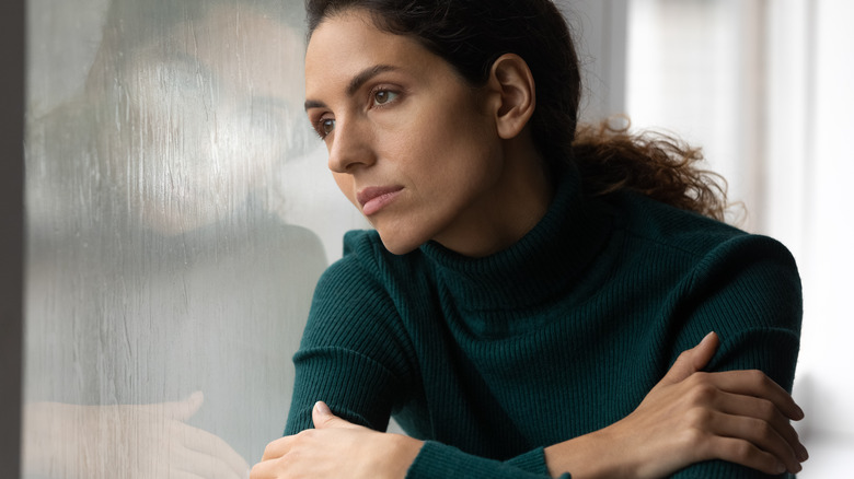 Woman looking lonely and staring out the window