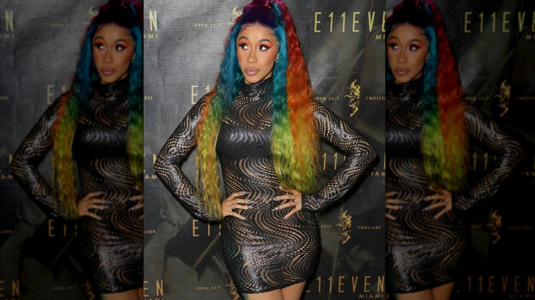 Cardi B in a swirly black dress and rainbow hair