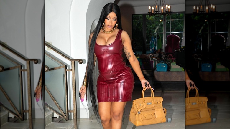 Cardi B in burgundy leather dress