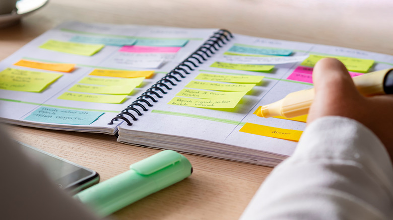 Person using highlighter and planner to organize their week