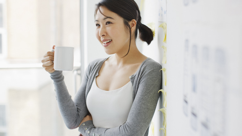 Calm woman drinking coffee at work