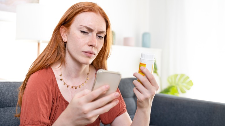 woman with phone and pills