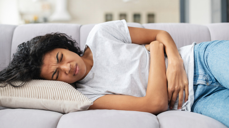 woman on couch with cramps