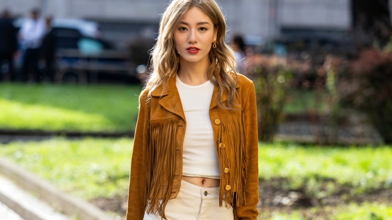 Woman wearing a brown suede jacket with fringe