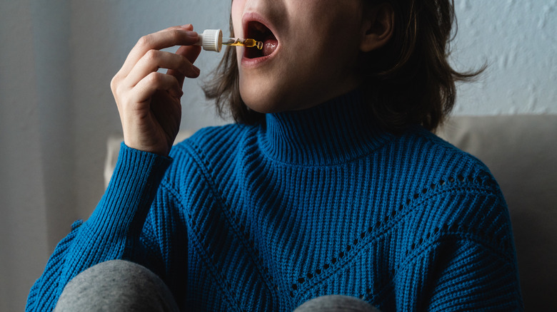 Woman taking CBG under her tongue