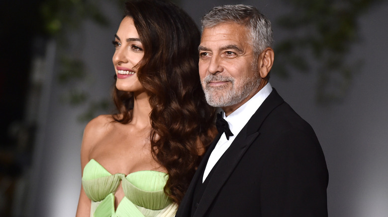 George and Amal Clooney posing on a red carpet