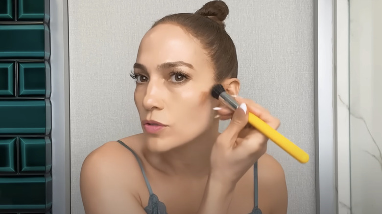 Jennifer Lopez contouring her face for a makeup tutorial.