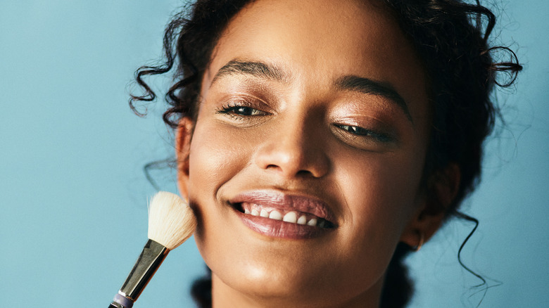 Woman applying blush