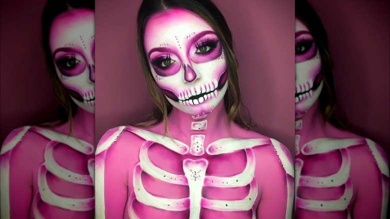 Girl with a full body of pink skeleton makeup.