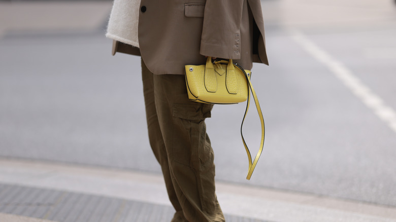 Woman holding small chartreuse bag