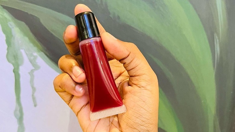 Instagram user @glossndglo holding tube of cherry lip gloss