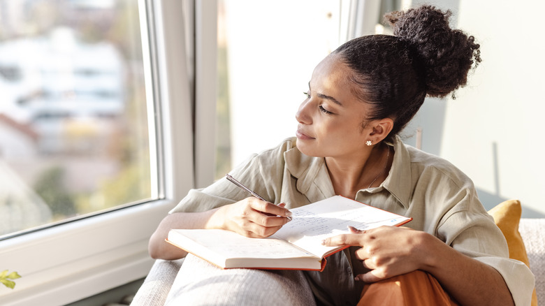 Woman journaling on couch