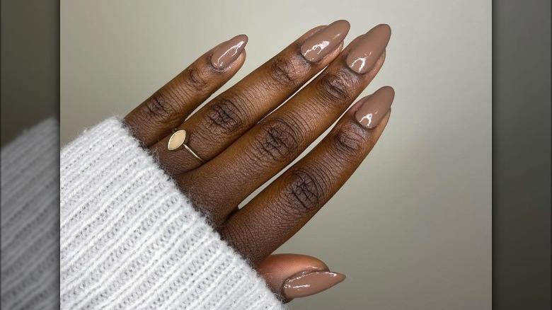 hand with shiny brown nail polish