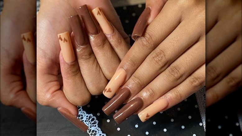hands with mixed brown nail polish