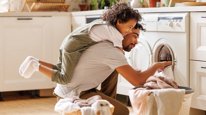 Parent and child doing laundry together