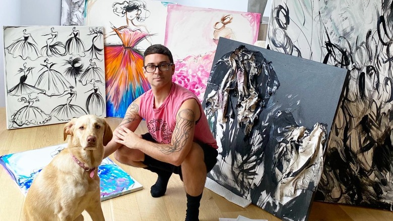 Christian Siriano posing with his dog and artwork