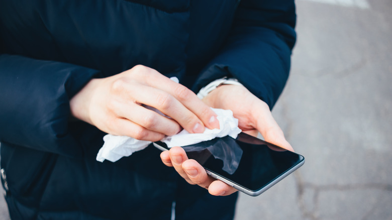 woman wiping down phone