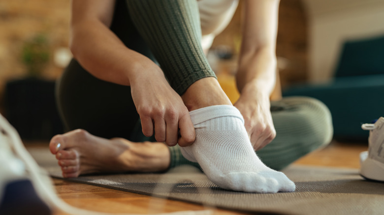 woman putting on a sock