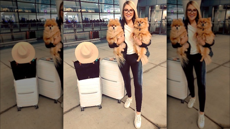 Woman holding dogs at airport