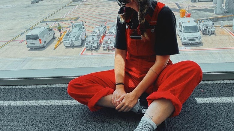 Woman wearing overalls in airport