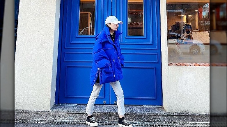 Woman walks past blue door 