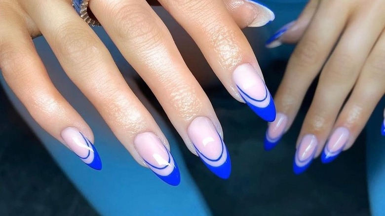 Hand with cobalt blue-tipped nails