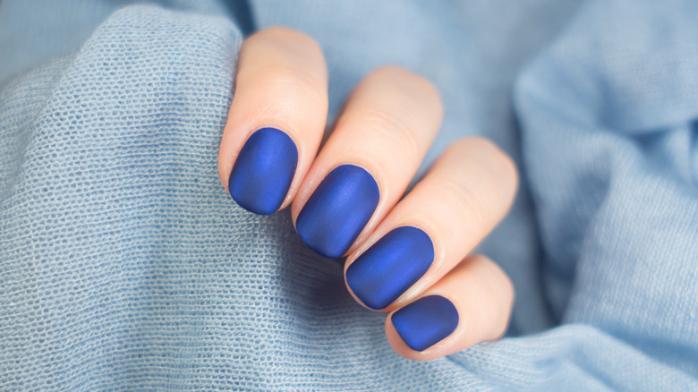 Closeup of gray sweater, cobalt blue nails