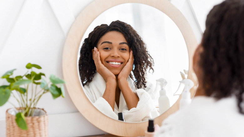 smiling woman applying face cream