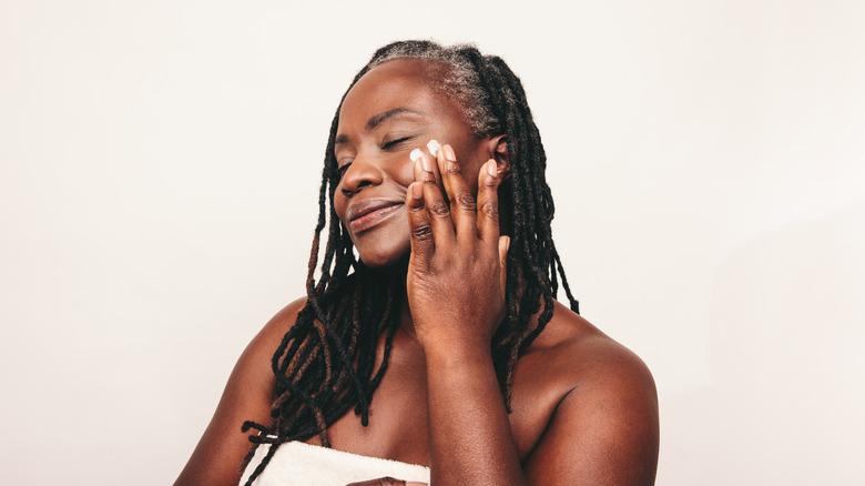 woman applying moisturizer