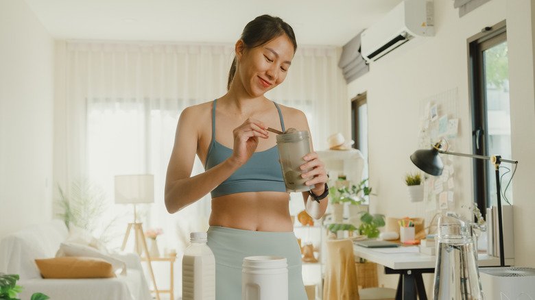 woman scooping collagen powder