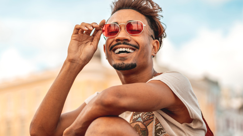 Smiling man wearing red sunglasses