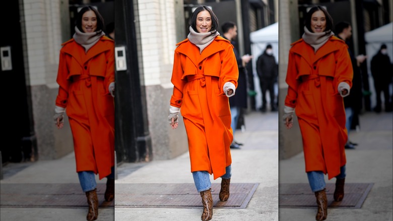 Woman in bright orange maxi coat