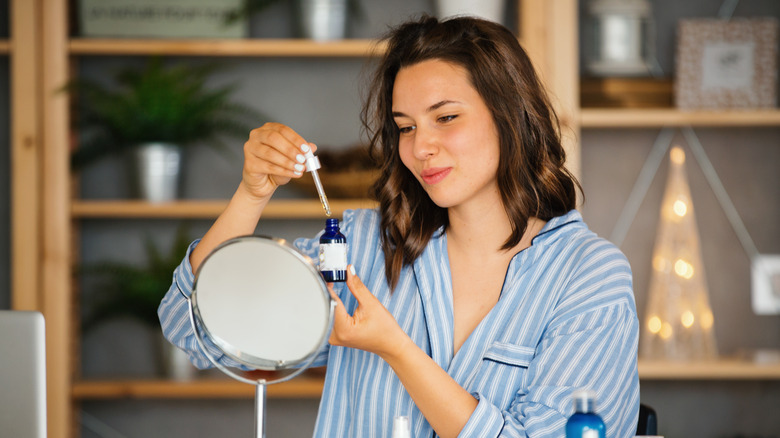 woman holding skincare serum