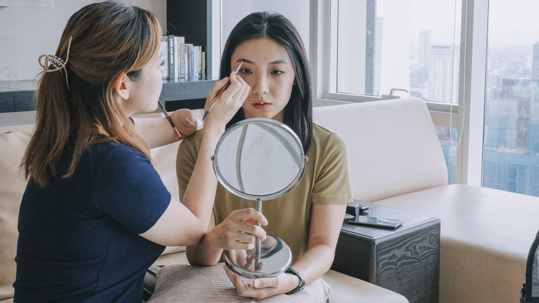 Woman applying eyebrow makeup