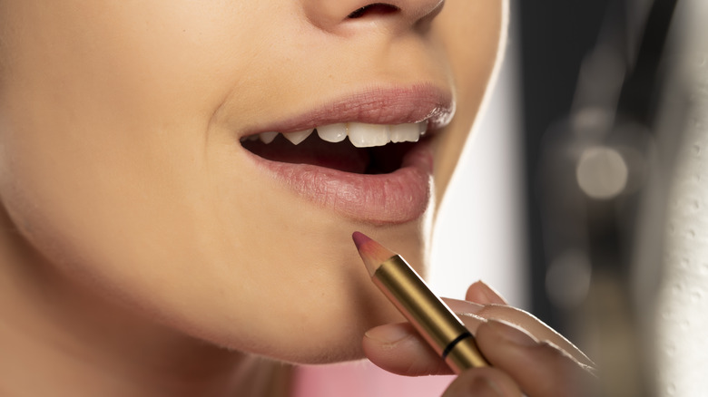 A woman applying lip liner